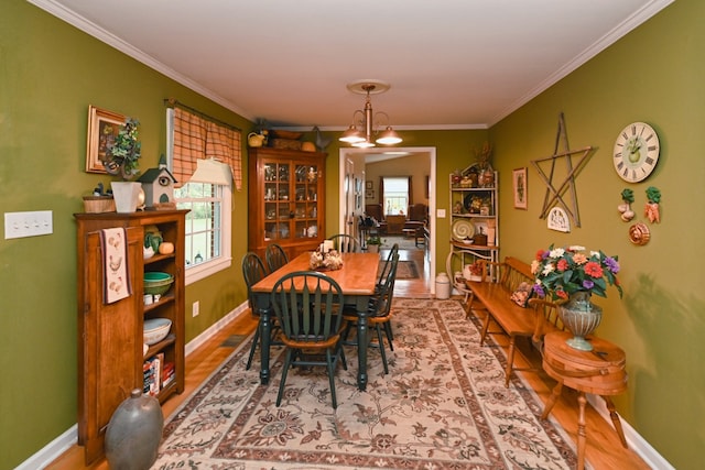 dining room with an inviting chandelier, crown molding, and hardwood / wood-style flooring