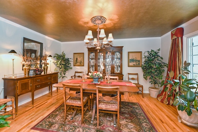 dining space with crown molding, a notable chandelier, and light hardwood / wood-style floors