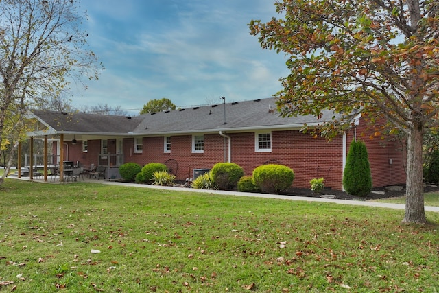 rear view of property featuring a patio and a yard