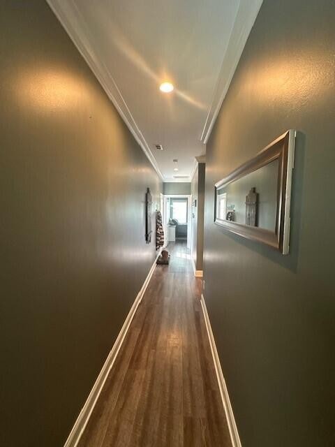 corridor featuring crown molding and dark hardwood / wood-style floors