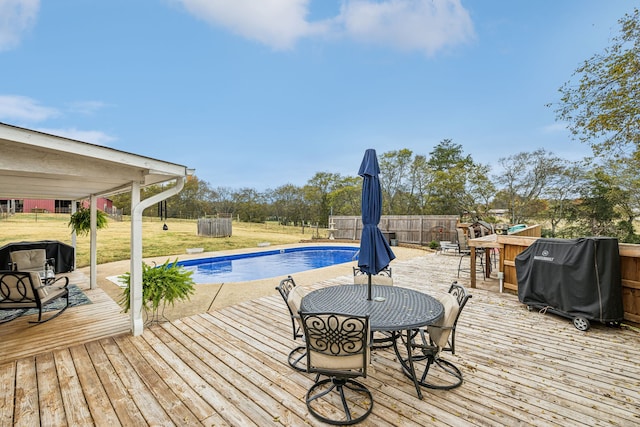 view of pool featuring a deck, grilling area, and a lawn