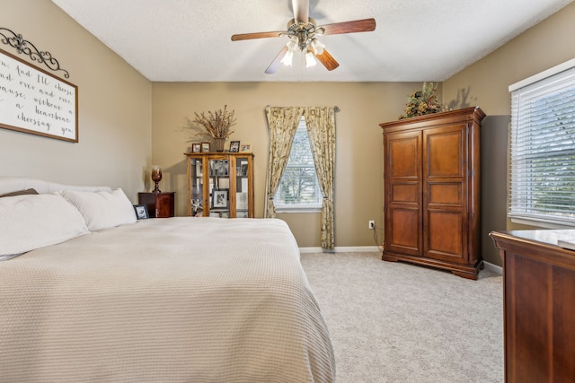 carpeted bedroom featuring ceiling fan and a textured ceiling