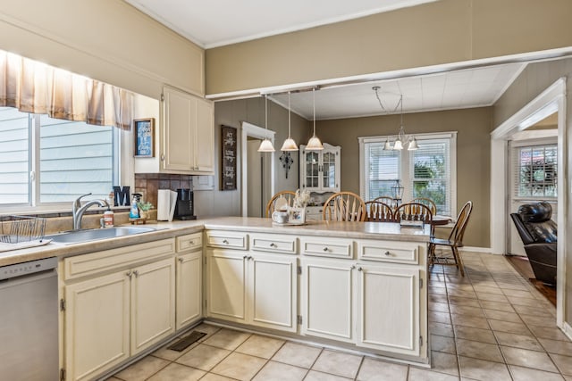 kitchen with a wealth of natural light, sink, dishwasher, and decorative light fixtures