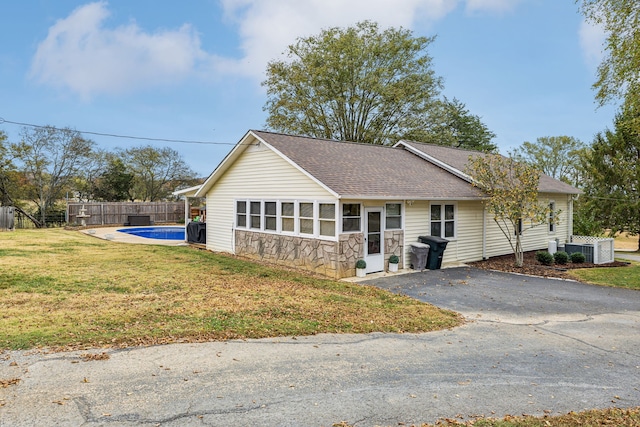 ranch-style house featuring a fenced in pool and a front lawn