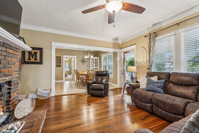 living room with ceiling fan, ornamental molding, a fireplace, and hardwood / wood-style floors