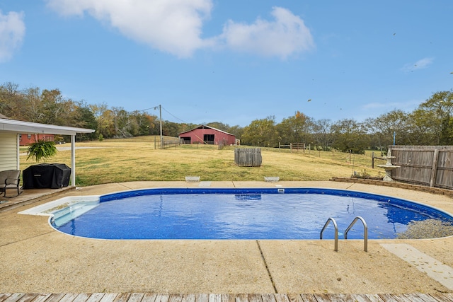 view of swimming pool with a yard