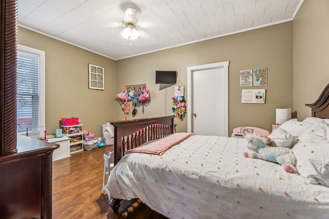 bedroom with crown molding, ceiling fan, and dark hardwood / wood-style flooring