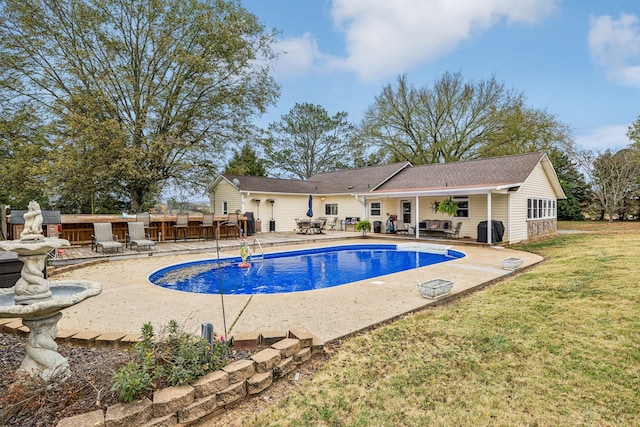 view of swimming pool featuring a yard and a patio area