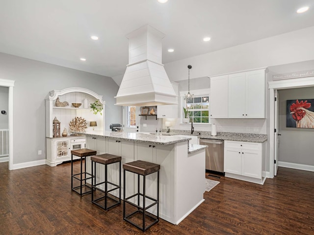 kitchen featuring dishwasher, white cabinets, dark hardwood / wood-style floors, decorative light fixtures, and a kitchen island