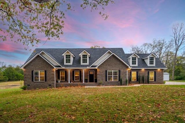 cape cod house with a lawn