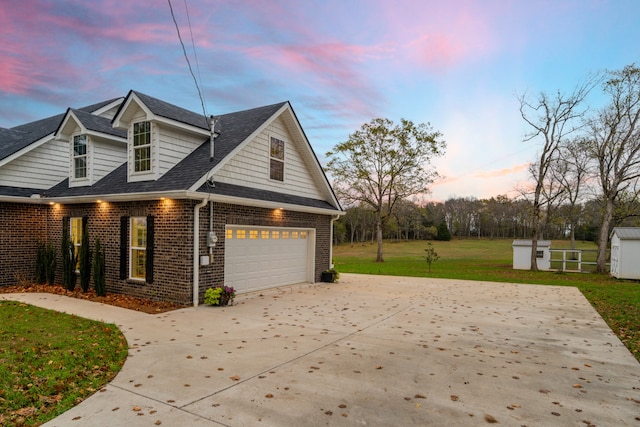 property exterior at dusk with a garage and a lawn