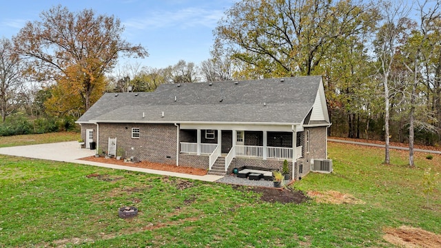 rear view of property with a lawn, central air condition unit, and covered porch