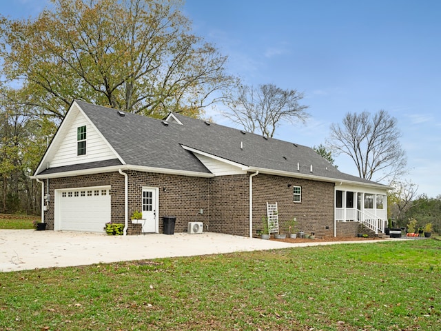 back of house with a garage and a lawn