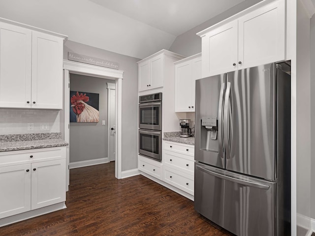 kitchen with stainless steel appliances, white cabinetry, dark wood-type flooring, and light stone counters