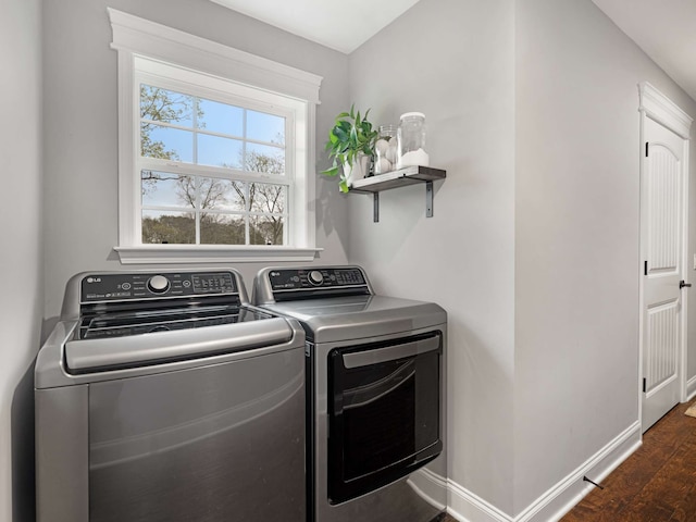 clothes washing area with washer and dryer and dark hardwood / wood-style floors