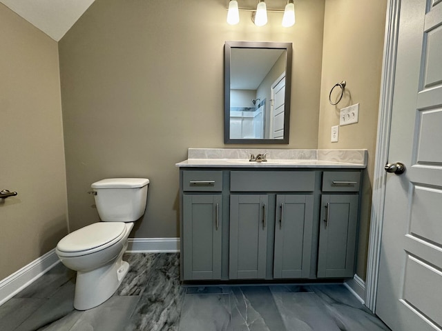 bathroom featuring lofted ceiling, vanity, and toilet