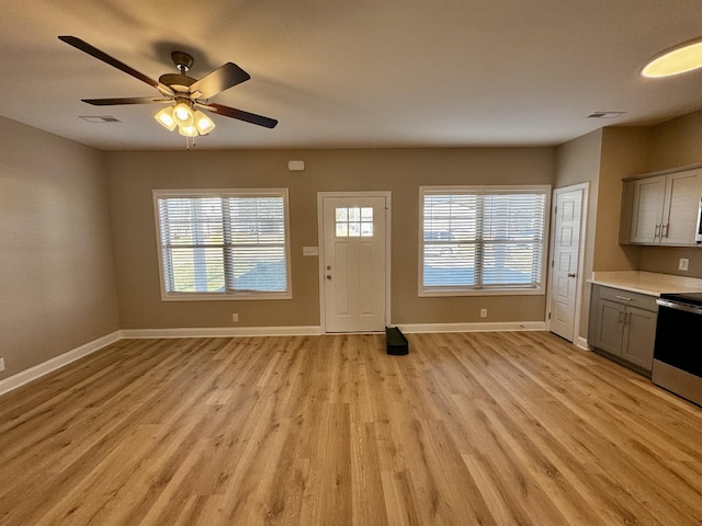 interior space with a wealth of natural light, light hardwood / wood-style floors, and ceiling fan