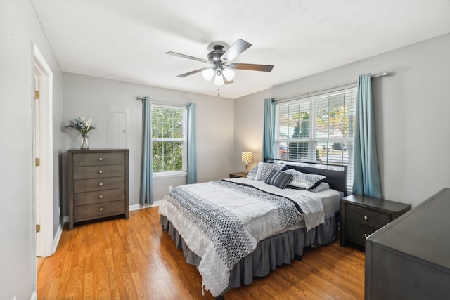 bedroom with multiple windows, light wood-type flooring, and ceiling fan