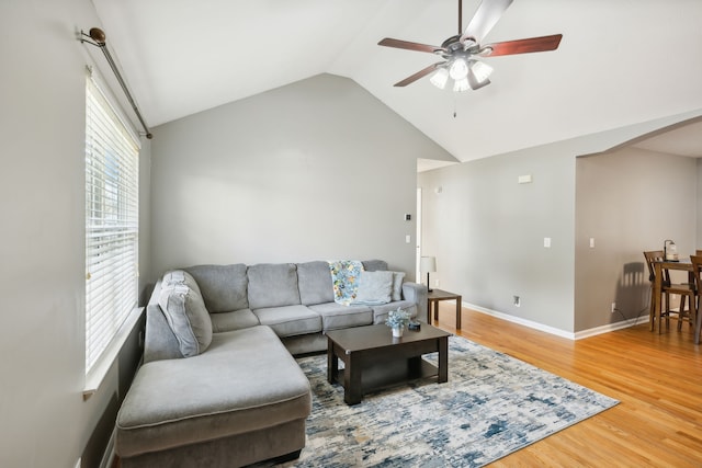 living room with ceiling fan, hardwood / wood-style flooring, and vaulted ceiling