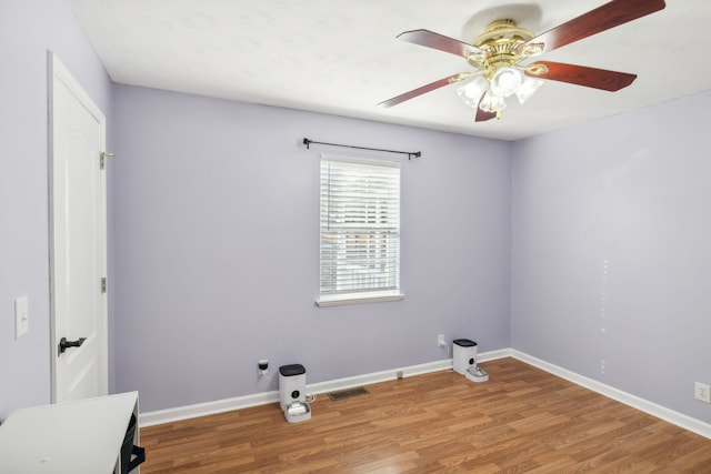 clothes washing area featuring ceiling fan and hardwood / wood-style floors