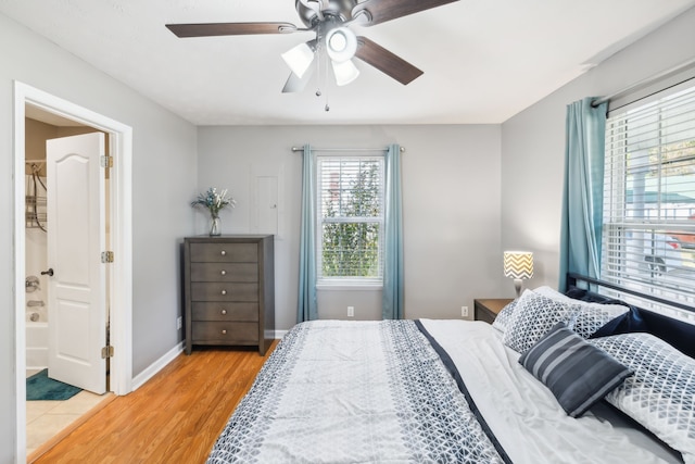 bedroom featuring ensuite bath, light hardwood / wood-style floors, and ceiling fan