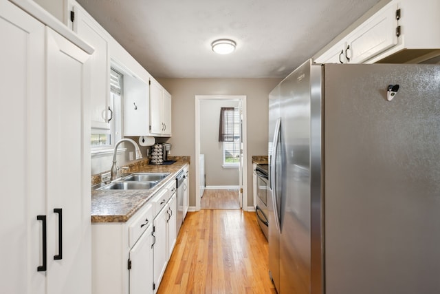 kitchen featuring appliances with stainless steel finishes, white cabinetry, sink, and a wealth of natural light