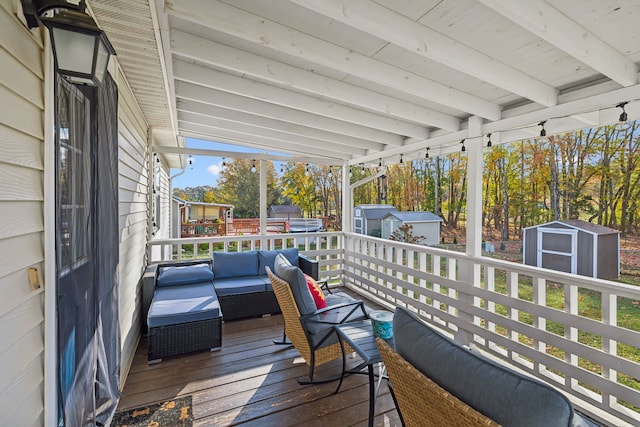 deck with an outdoor living space and a shed