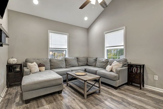 living room featuring hardwood / wood-style floors, high vaulted ceiling, and ceiling fan