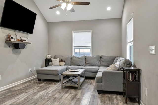 living room with ceiling fan, lofted ceiling, and hardwood / wood-style floors