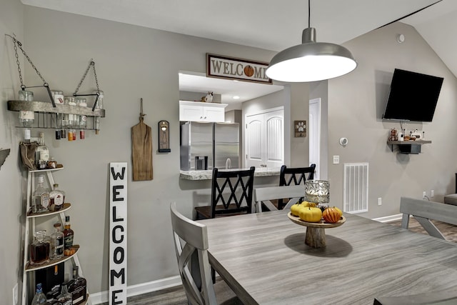 dining space with lofted ceiling and hardwood / wood-style flooring