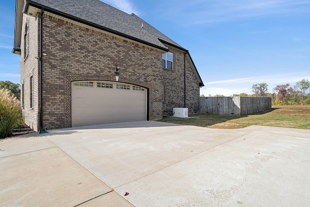 view of side of property with a lawn and a garage