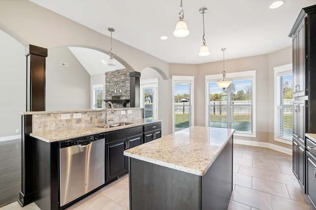 kitchen with decorative light fixtures, sink, dishwasher, decorative columns, and a center island