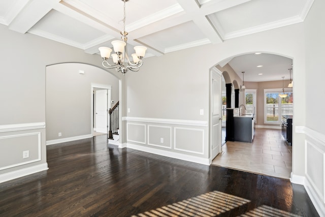 unfurnished dining area with beamed ceiling, dark hardwood / wood-style floors, crown molding, and coffered ceiling