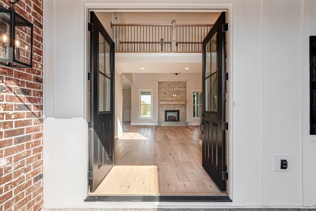 foyer with baseboards, a fireplace, and wood finished floors
