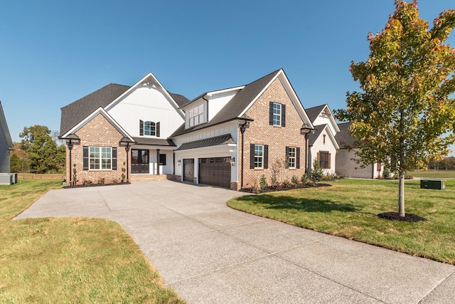 view of front of property featuring brick siding, a garage, board and batten siding, a front yard, and driveway