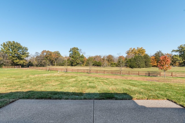 view of yard featuring fence and a rural view