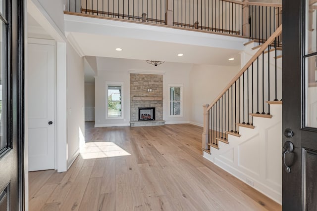 foyer with a stone fireplace and light hardwood / wood-style flooring