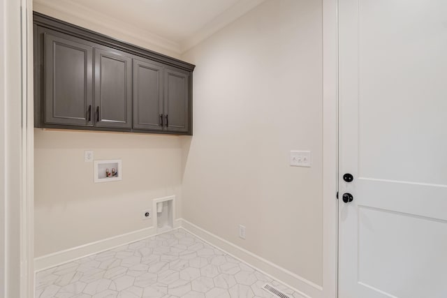 washroom with cabinet space, crown molding, hookup for a washing machine, electric dryer hookup, and baseboards
