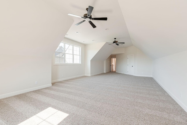 additional living space with ceiling fan, light carpet, baseboards, and lofted ceiling