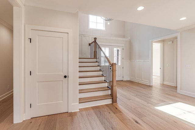 staircase with recessed lighting, a notable chandelier, and wood finished floors