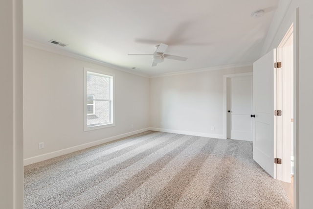 carpeted empty room with crown molding and ceiling fan