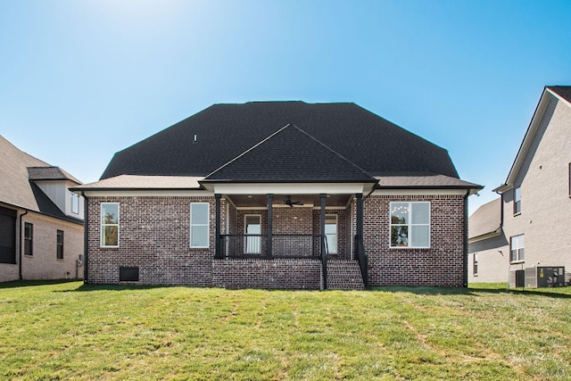 back of property with a lawn and brick siding