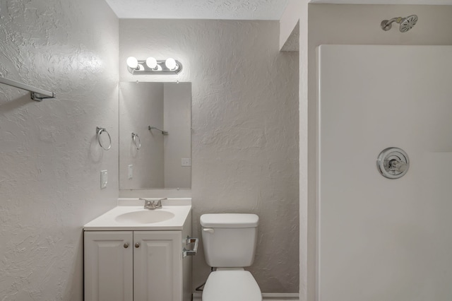 bathroom featuring vanity, a textured ceiling, and toilet