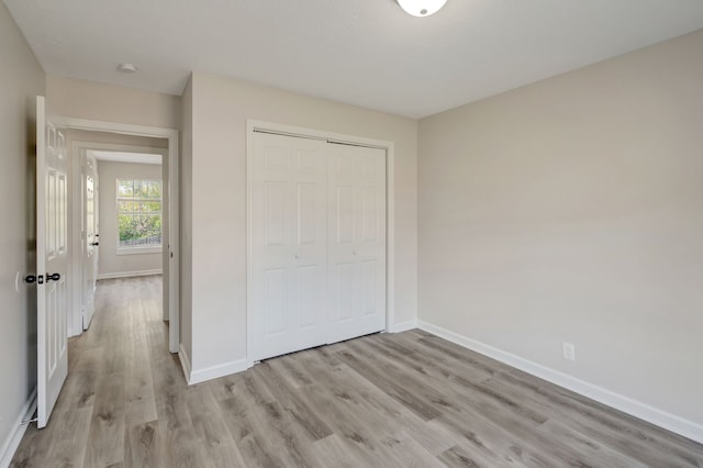 unfurnished bedroom featuring light hardwood / wood-style flooring and a closet