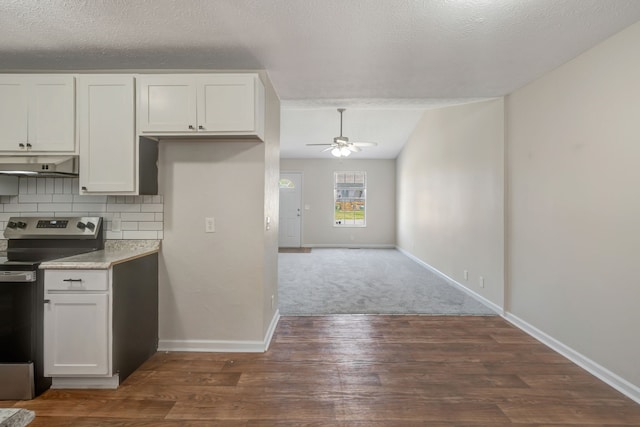 kitchen with decorative backsplash, white cabinets, a textured ceiling, and electric stove