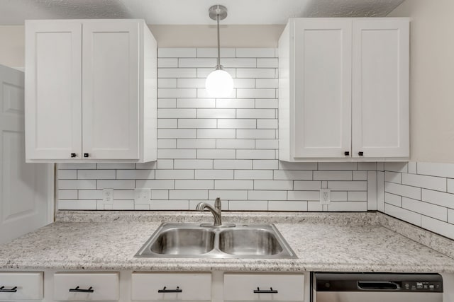 kitchen featuring sink, hanging light fixtures, dishwasher, and white cabinets