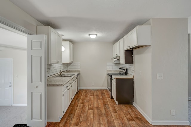 kitchen with stainless steel range with electric stovetop, white cabinets, tasteful backsplash, and light wood-type flooring