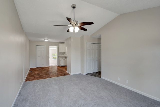 interior space with dark hardwood / wood-style floors, ceiling fan, and vaulted ceiling