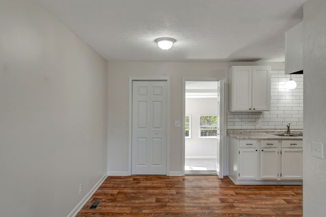 kitchen featuring sink, white cabinetry, and dark hardwood / wood-style floors