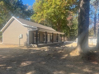 view of side of property featuring covered porch